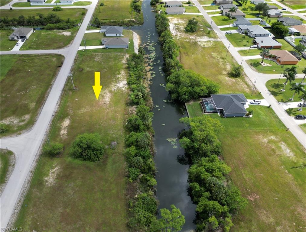 Aerial view of property and surrounding area featuring a large body of water and nearby suburban area