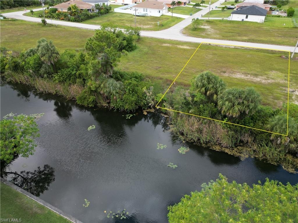 Aerial view of property and surrounding area featuring property boundaries highlighted and a nearby body of water