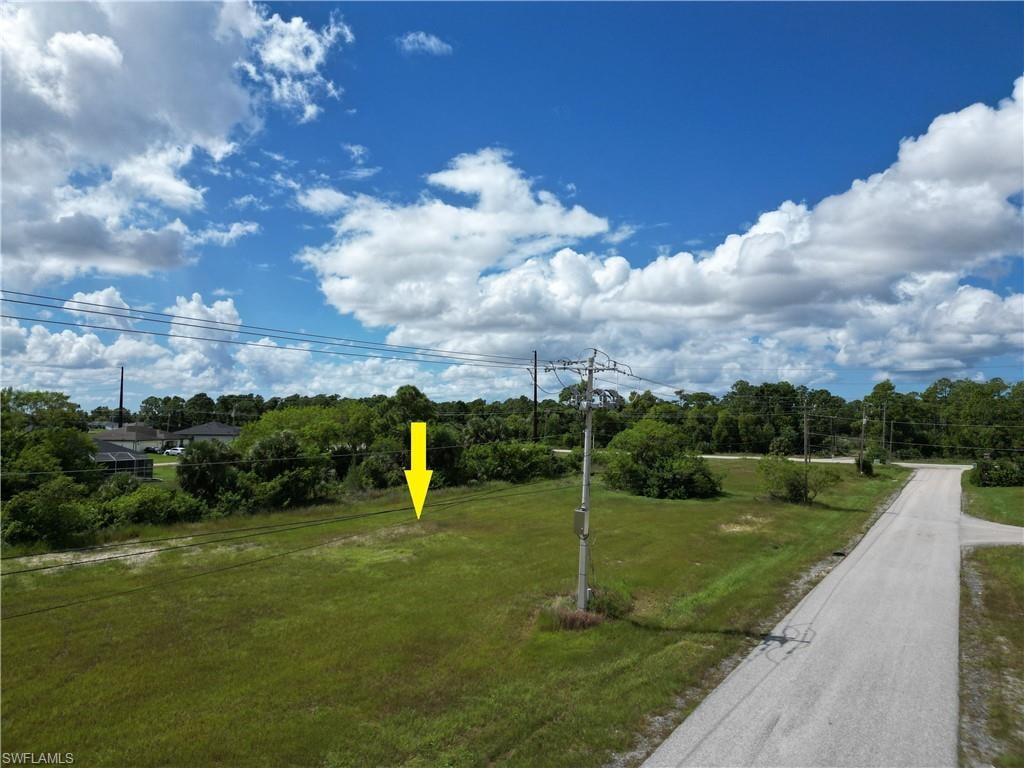View of property's community featuring a yard and view of wooded area