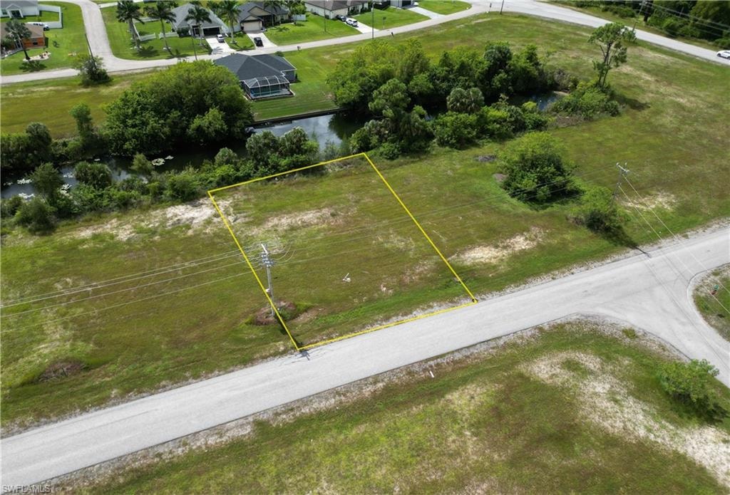 Aerial view of property and surrounding area with property parcel outlined and a large body of water