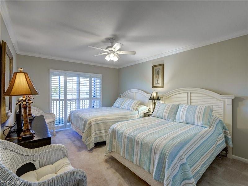 Bedroom with carpet floors, crown molding, and a ceiling fan