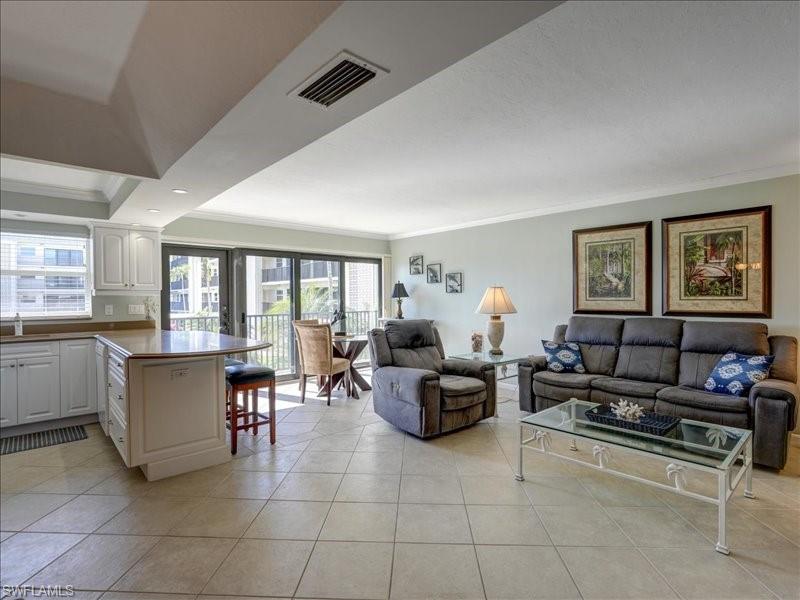 Living room with crown molding and light tile patterned floors