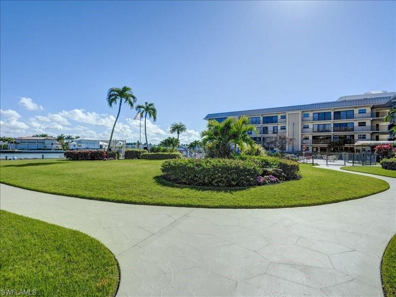 View of property's community with a lawn