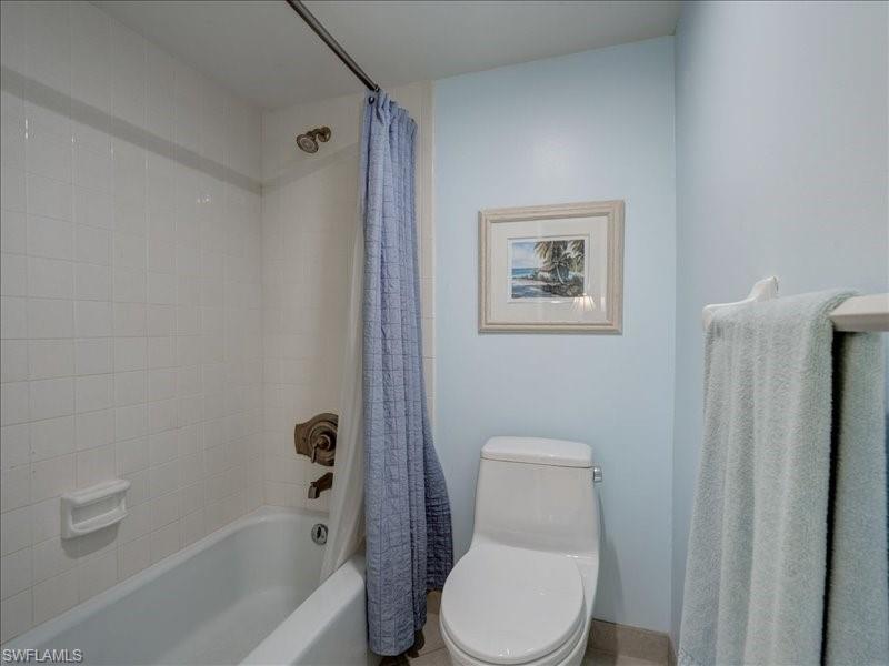 Full bath with shower / bath combination with curtain and toilet