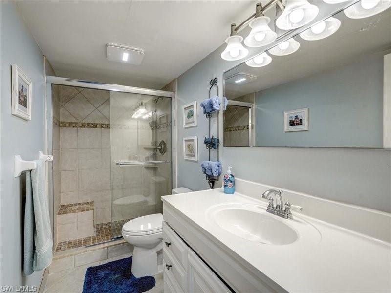 Bathroom with vanity, a stall shower, and light tile patterned floors