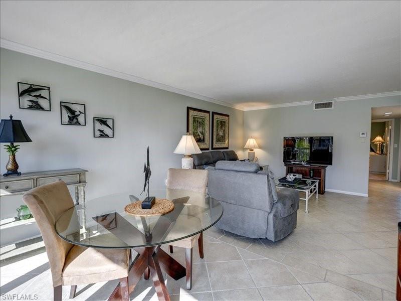 Dining area with crown molding and light tile patterned floors
