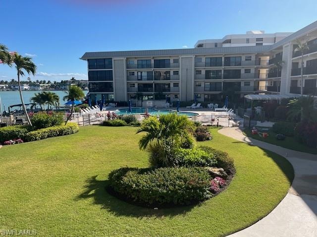 View of community featuring a pool and a yard