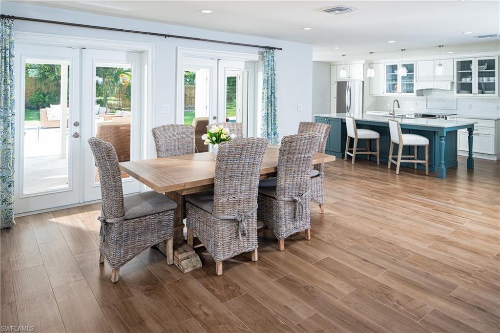 Dining space with french doors, light wood-style floors, and recessed lighting