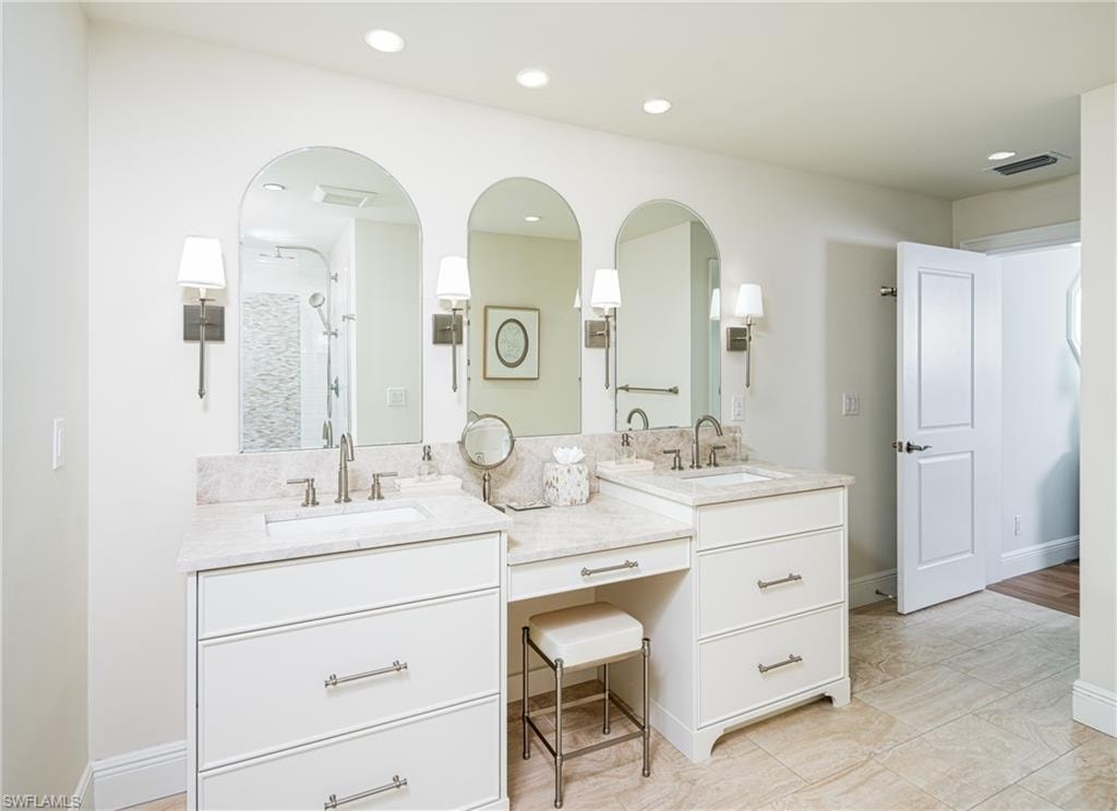Bathroom with a shower stall, double vanity, and recessed lighting