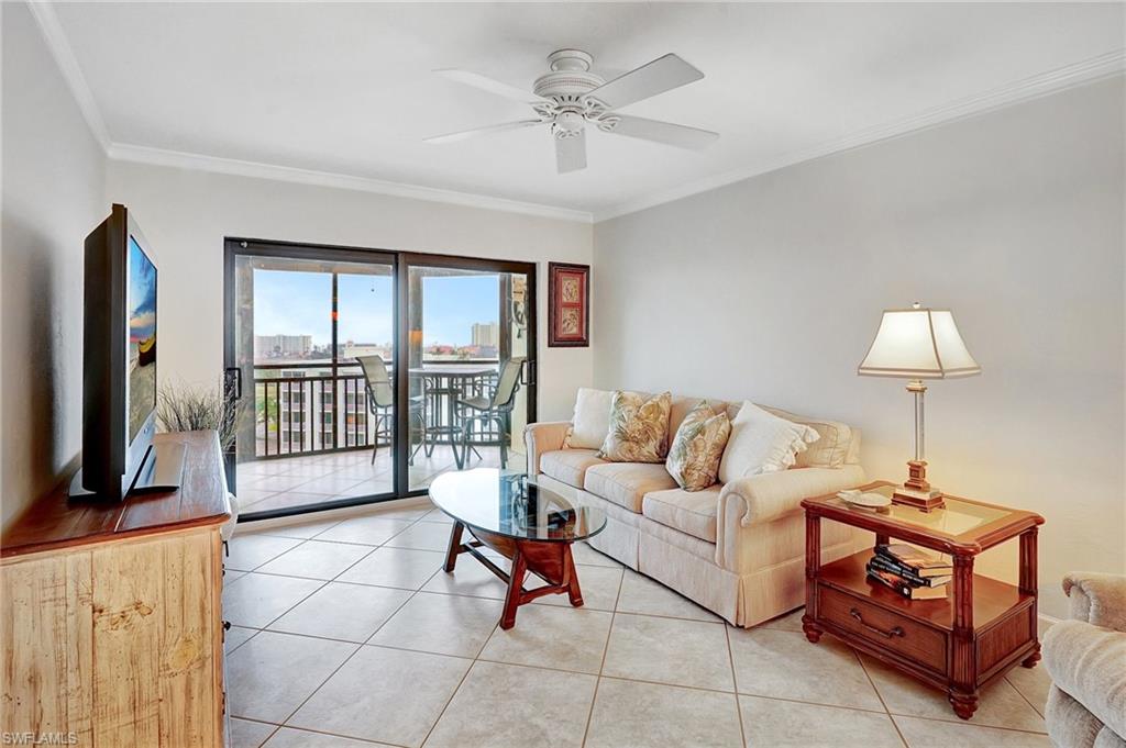 Living area featuring tile patterned floors, ornamental molding, and ceiling fan