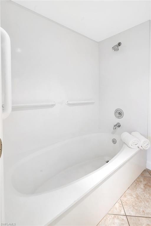 Full bath with tile patterned floors and shower / bath combination