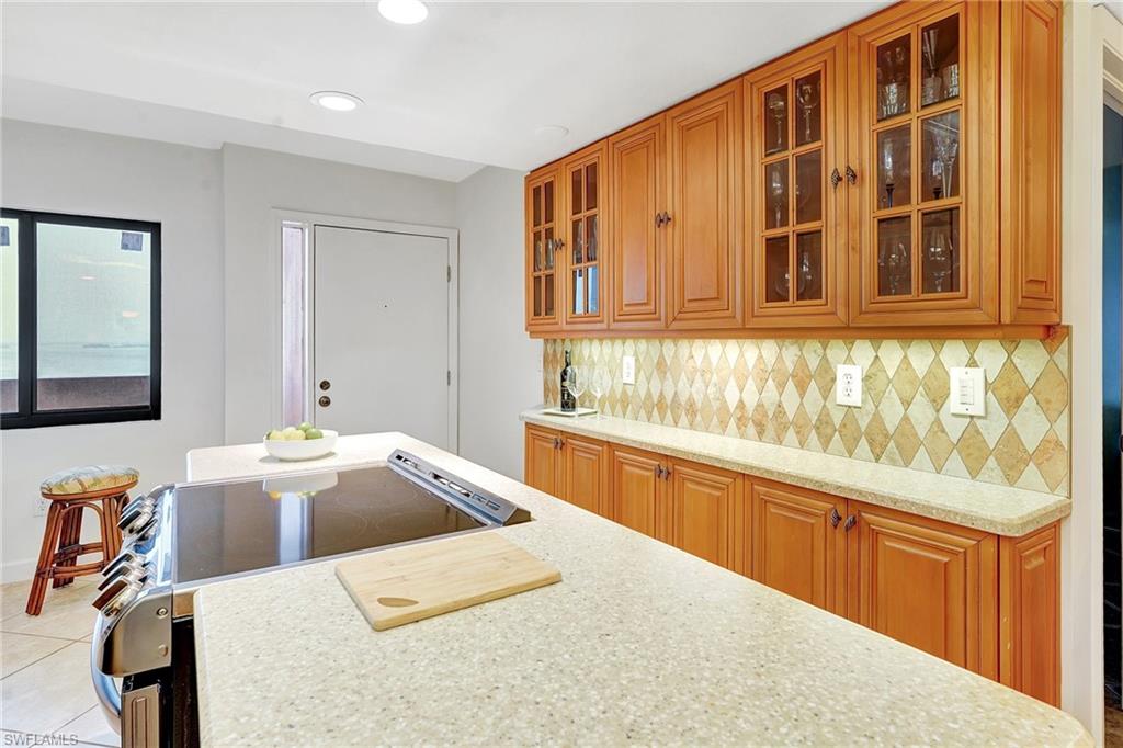 Kitchen featuring tasteful backsplash, light stone countertops, stainless steel range with electric stovetop, light tile patterned floors, and recessed lighting