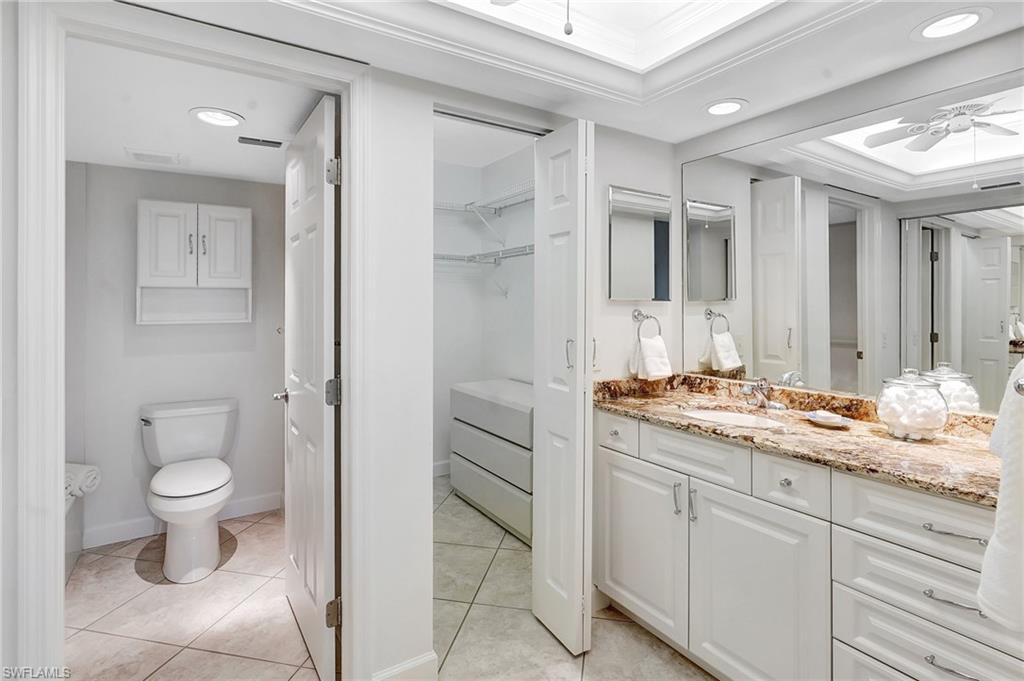 Full bath with a ceiling fan, vanity, light tile patterned floors, a walk in closet, and recessed lighting