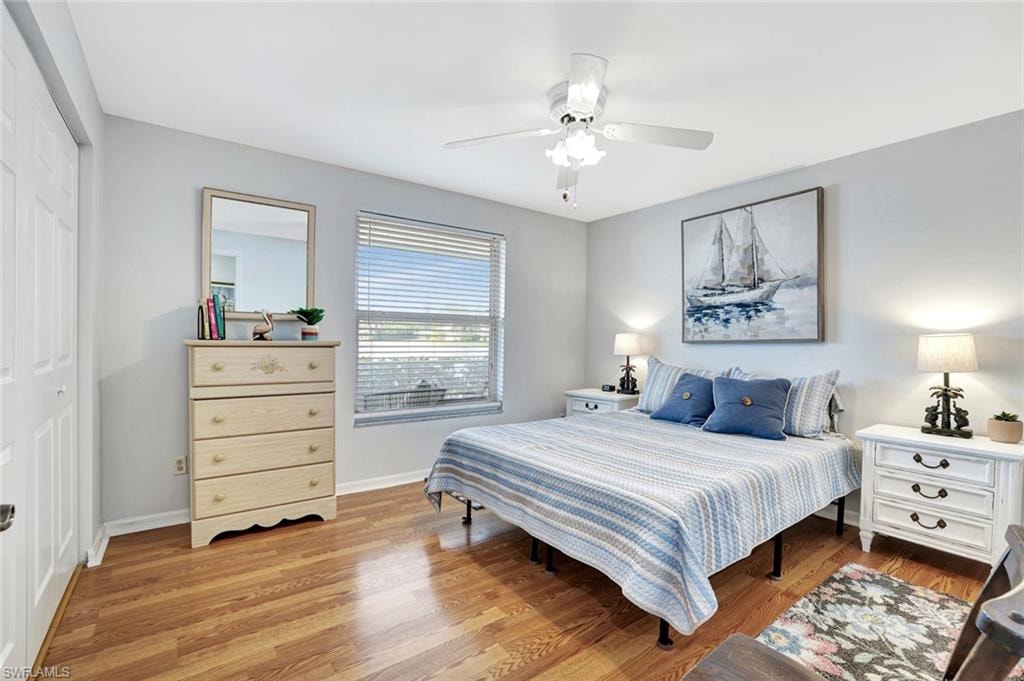 Bedroom with light wood-style floors, ceiling fan, and a closet