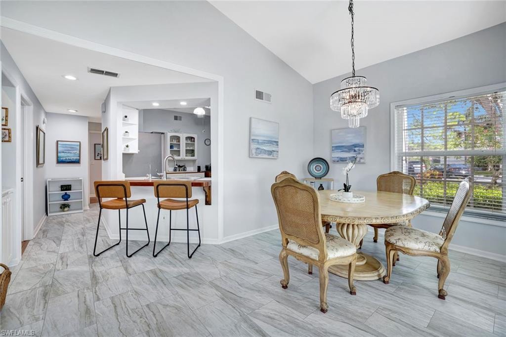 Dining space with vaulted ceiling and a chandelier