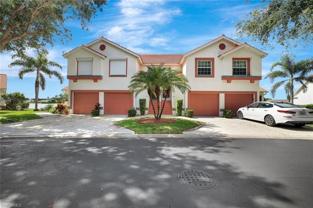 Mediterranean / spanish house with stucco siding, driveway, an attached garage, and a tile roof