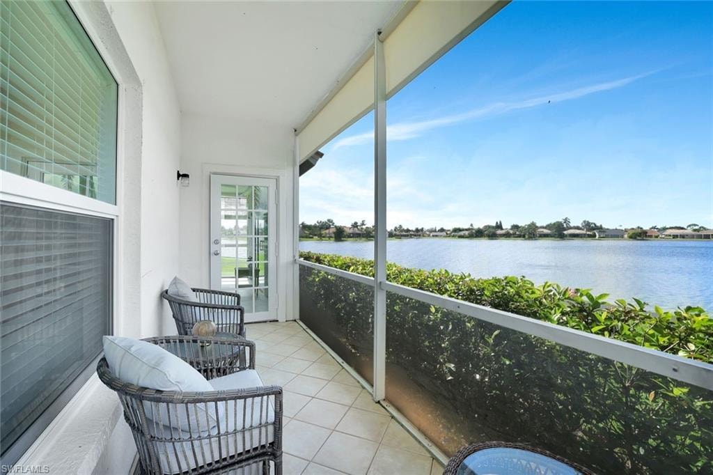 Balcony featuring a water view and a sunroom
