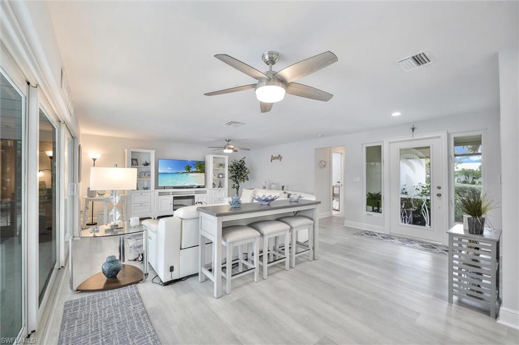Living area featuring light wood-style floors, ceiling fan, and recessed lighting