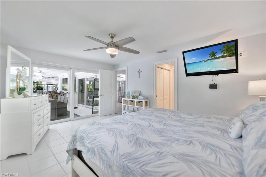 Bedroom with light tile patterned flooring, access to outside, ceiling fan, and a closet