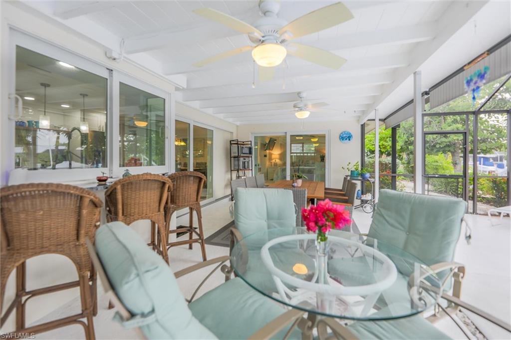 Sunroom / solarium featuring beam ceiling, outdoor dining space, a patio area, and ceiling fan