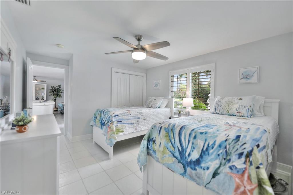 Bedroom with a closet, light tile patterned floors, and ceiling fan