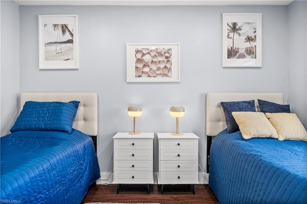 Bedroom with dark wood-style floors and baseboards