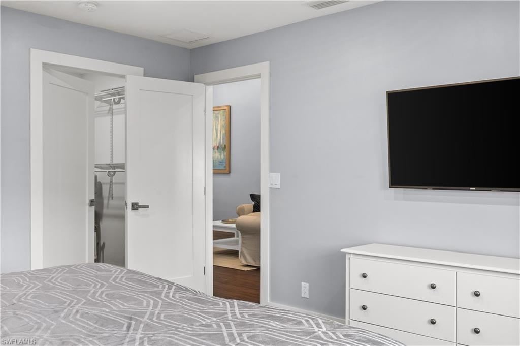 Bedroom with a walk in closet and baseboards