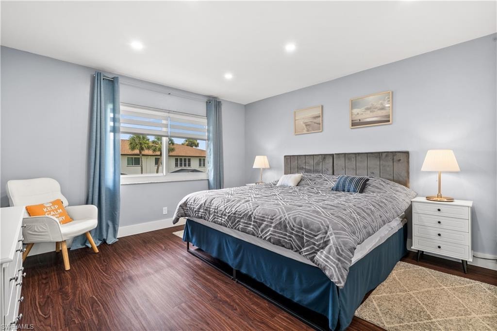 Bedroom with dark wood finished floors and recessed lighting