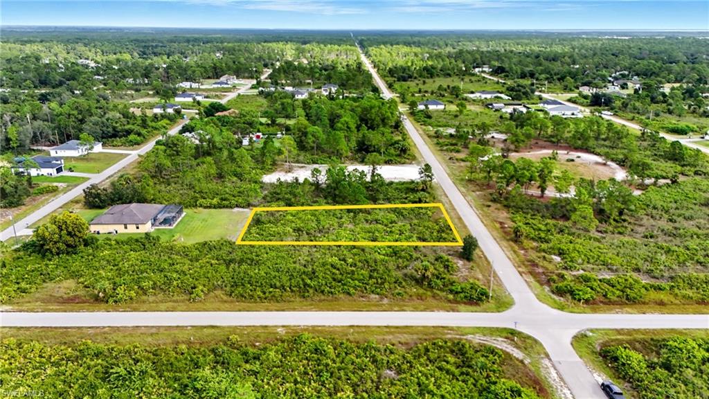 Aerial view of property's location featuring property parcel outlined and a heavily wooded area