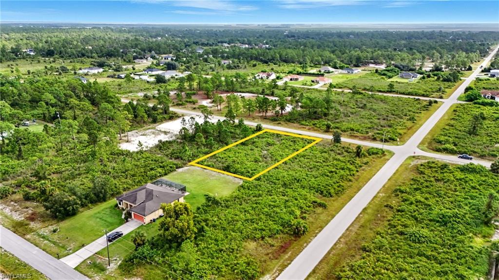 Aerial view of property and surrounding area with property parcel outlined