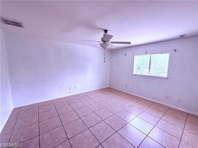 Spare room with a ceiling fan and light tile patterned flooring