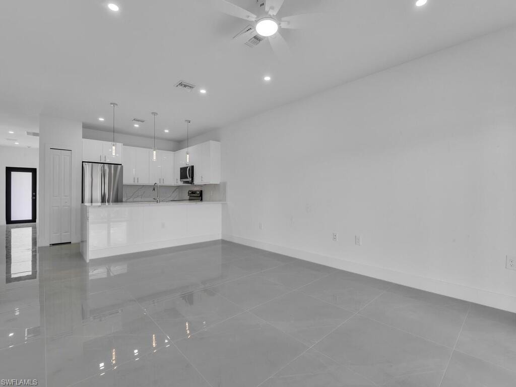 Unfurnished living room featuring recessed lighting, light tile patterned flooring, and a ceiling fan