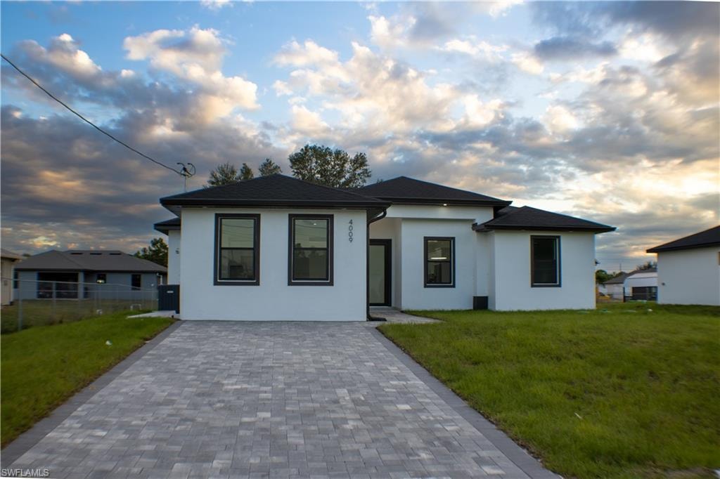 View of front of home featuring stucco siding and decorative driveway