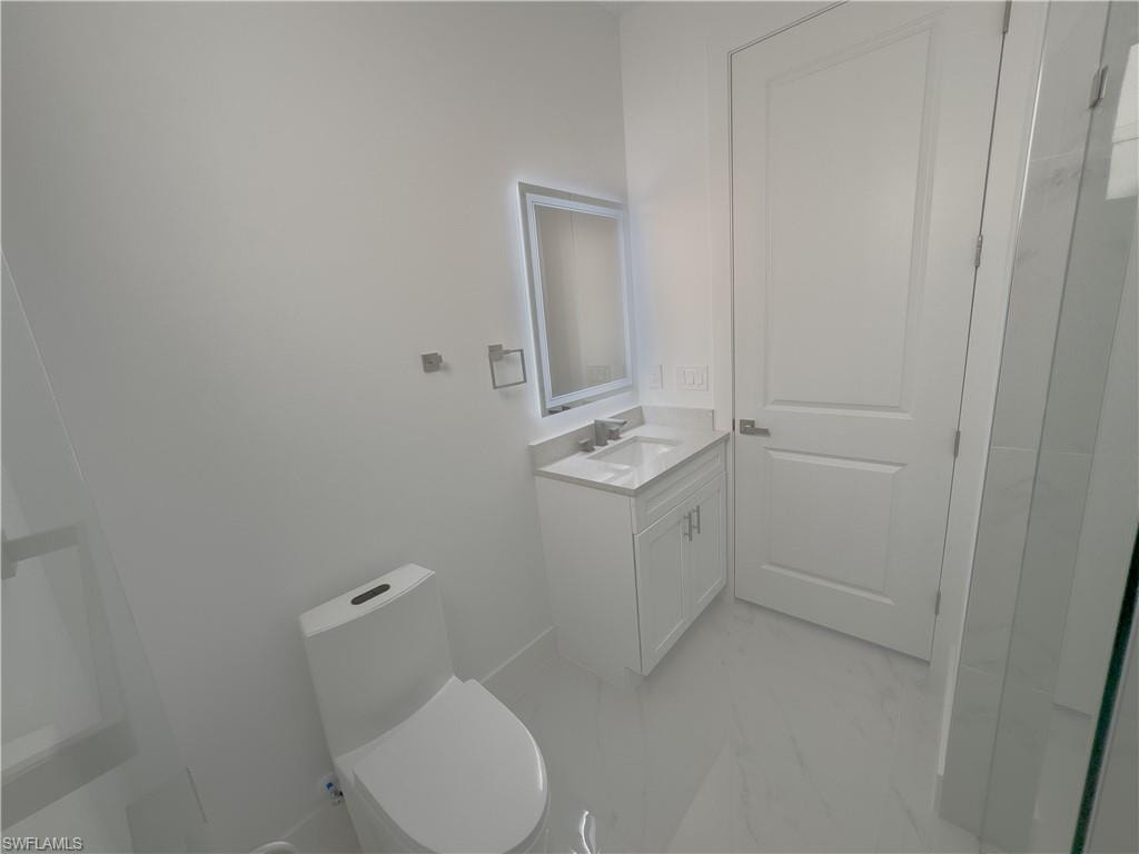 Bathroom with vanity and light marble finish floors