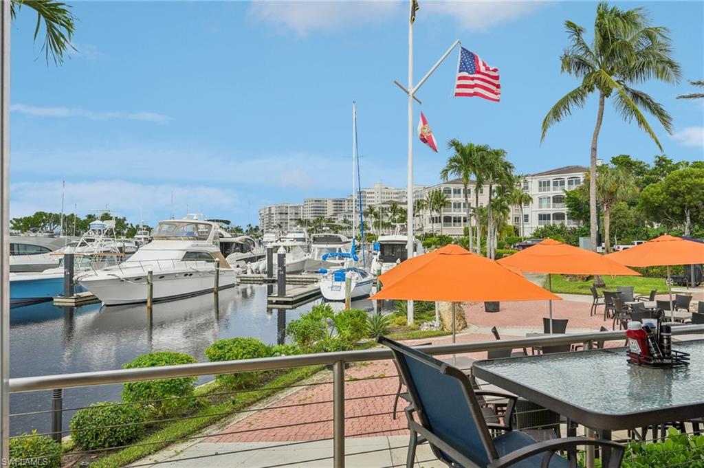 Balcony featuring a water view, view of marina, and a dock