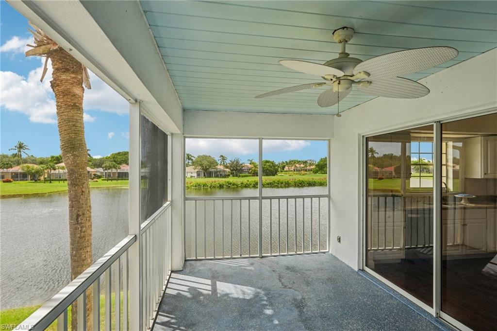 Unfurnished sunroom featuring a ceiling fan, a residential view, and a water view