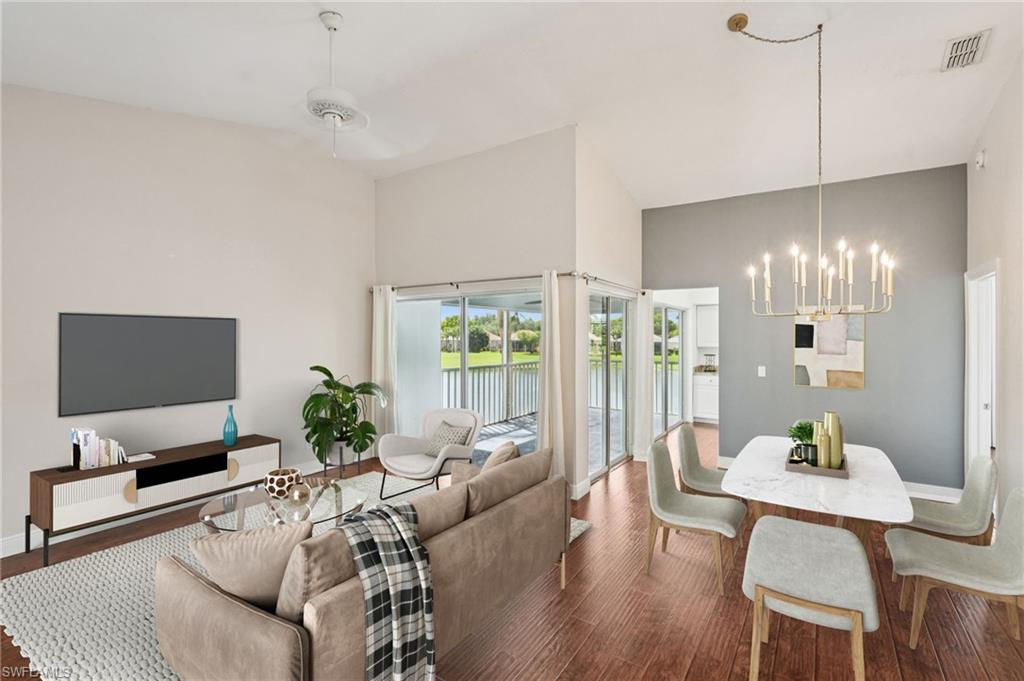 Living area featuring dark wood-type flooring, a chandelier, and ceiling fan