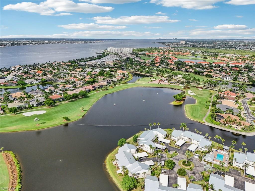 Aerial view of residential area with a golf course and a nearby body of water
