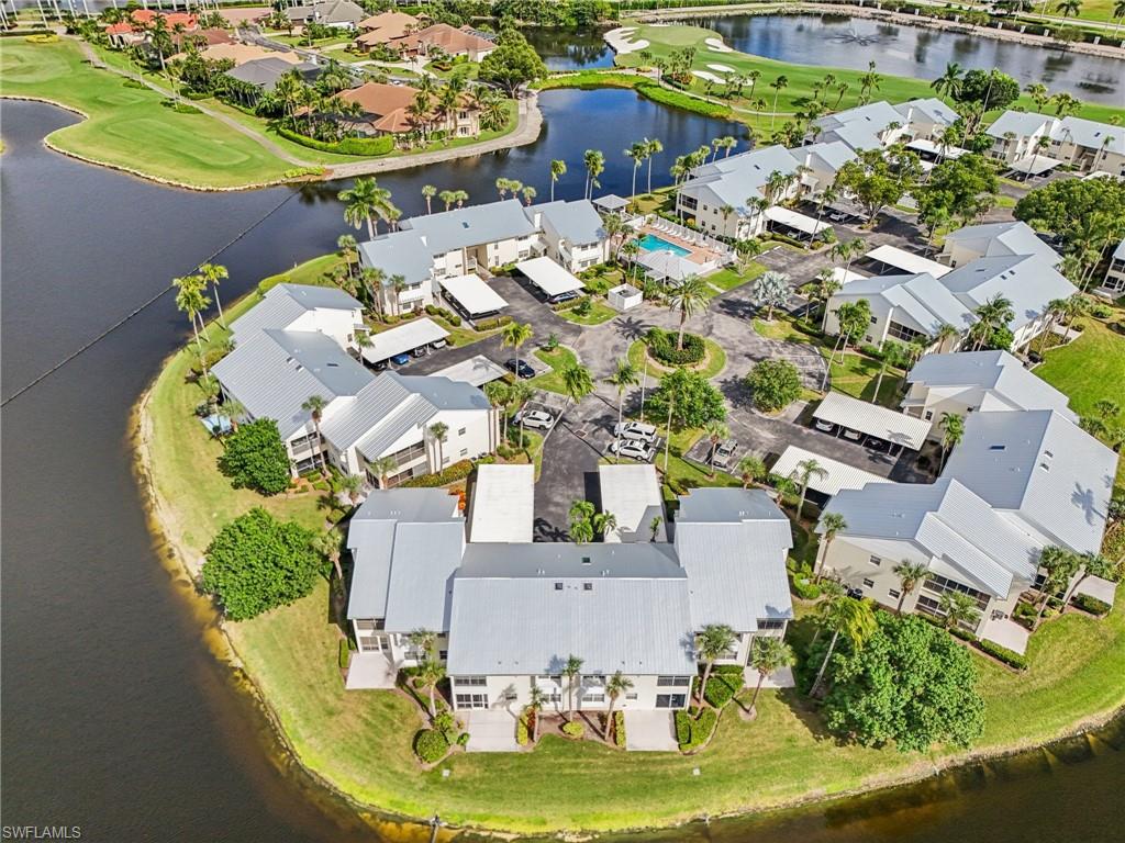 Aerial view of property's location featuring a large body of water, a golf club, and nearby suburban area