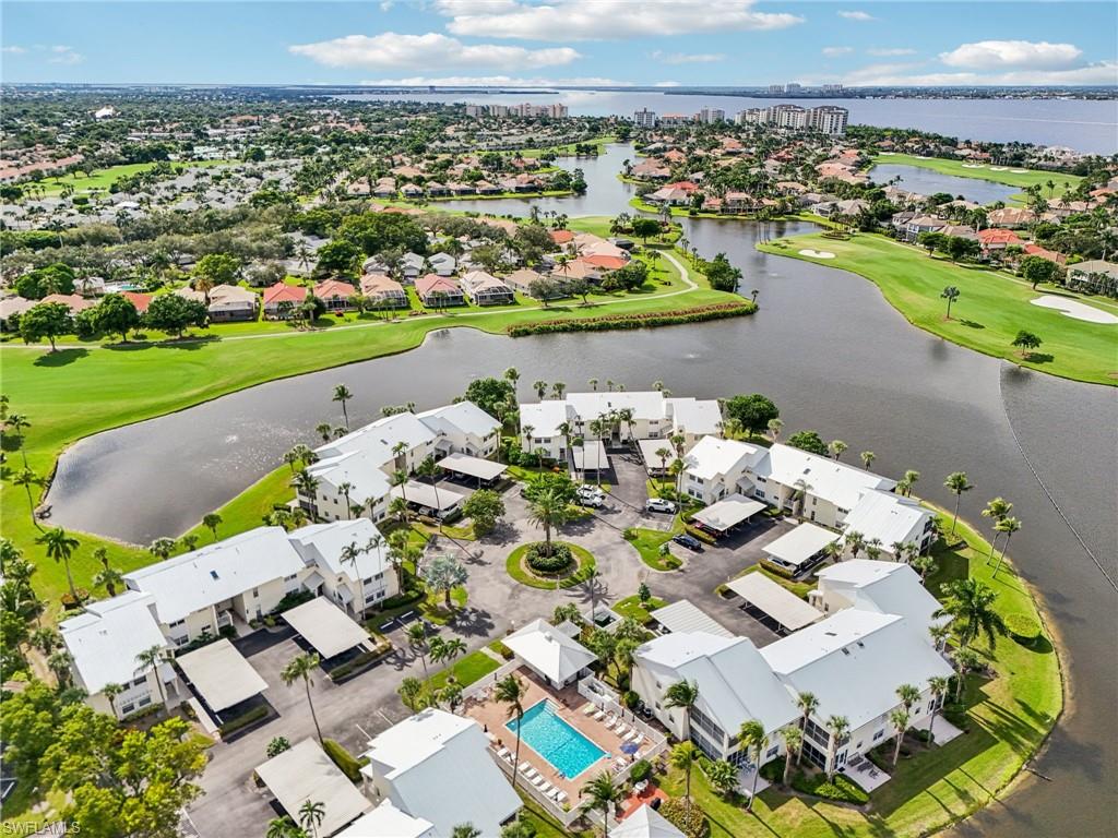 Aerial perspective of suburban area with a golf course and a nearby body of water