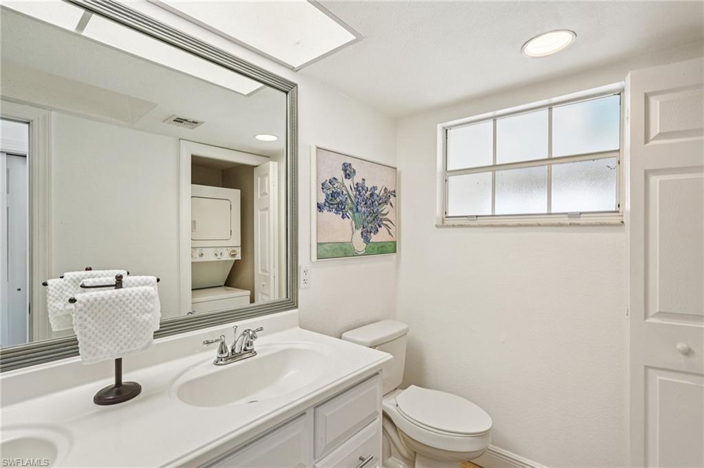 Bathroom featuring double vanity, estacked washer and dryer, and recessed lighting