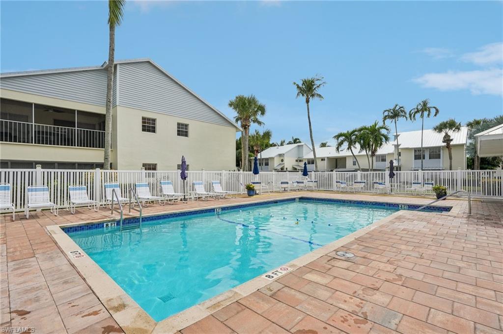 Community pool with a patio area and a residential view