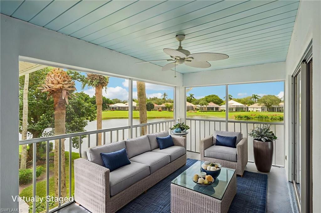 Sunroom featuring a ceiling fan, outdoor lounge area, a residential view, and a water view