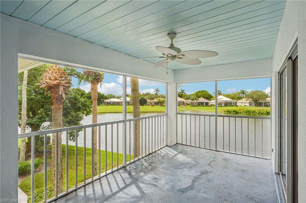 Unfurnished sunroom with a ceiling fan, a water view, and a residential view