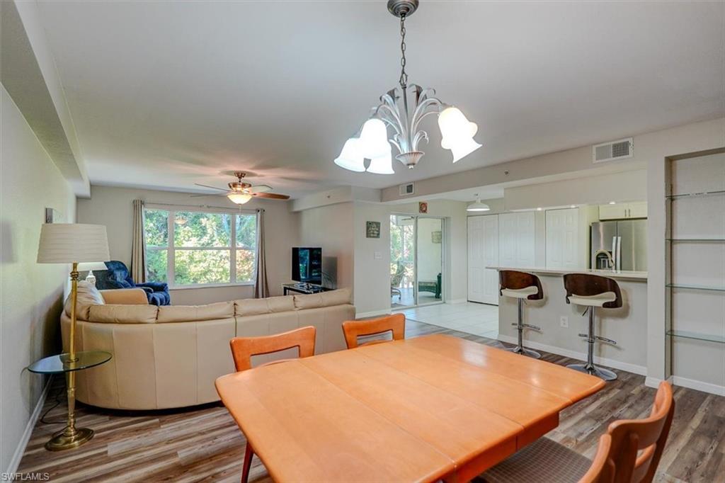 Dining space with light wood-style floors, a chandelier, and ceiling fan