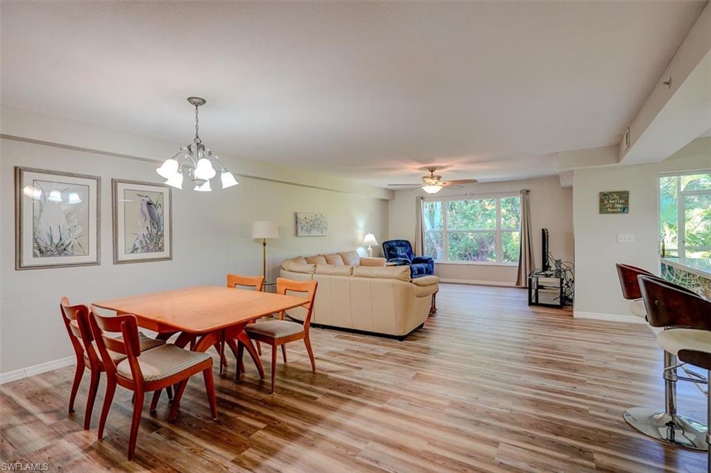 Dining space with light wood-type flooring, a chandelier, and a ceiling fan