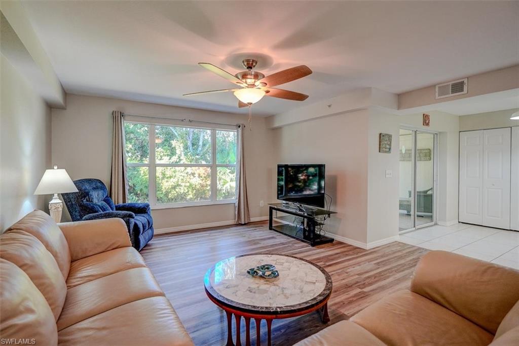 Living room with light wood-style floors and ceiling fan
