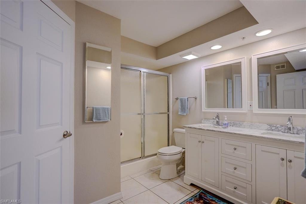 Full bath featuring light tile patterned flooring, double vanity, recessed lighting, and shower / bath combination with glass door