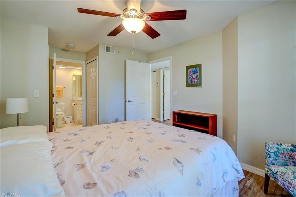 Bedroom featuring connected bathroom, wood finished floors, ceiling fan, and a closet