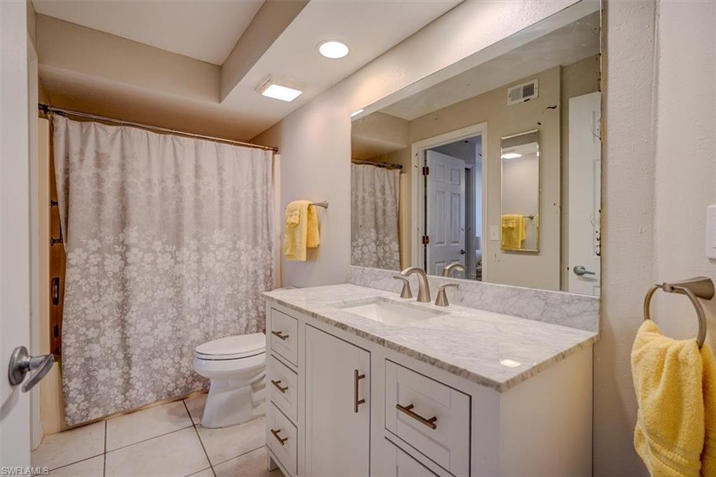 Bathroom featuring vanity, light tile patterned flooring, and a shower with shower curtain
